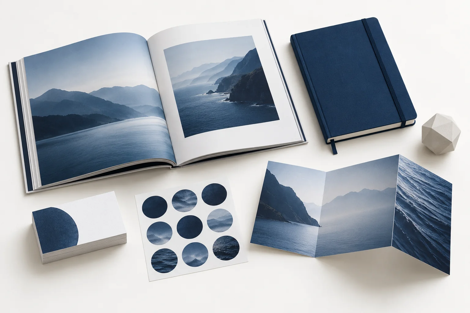 Composição ilustrativa com livro, caderno, adesivos, papelaria e peça impressa em 3D
